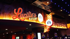 Señal de Lucille's Eatery con una flecha de neón apuntando a la derecha, indicando el camino hacia el restaurante.