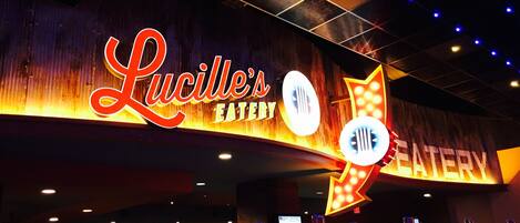 Segnaletica di Lucille's Eatery con una freccia al neon che indica a destra la direzione del ristorante.