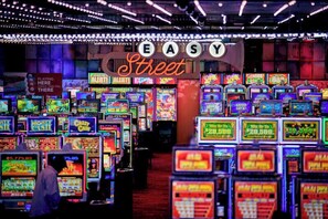 Un casino doté de nombreuses machines à sous et d’un panneau lumineux au néon sur lequel on peut lire : « EASY Street ».