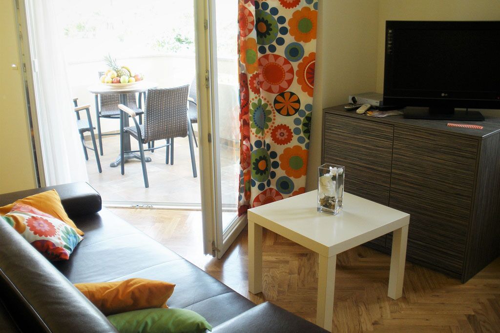 A living room with a sofa, a coffee table, a TV, and a cabinet.