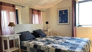 A bedroom with a bed, a bedside table, a lamp, a window with curtains, and a wall-mounted picture. - Villa Mary near Rovinj (Rovinj)