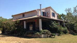 A two-story house with a tiled roof, a chimney, and a covered porch with chairs. - Villa Mary near Rovinj (Rovinj)