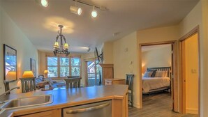 Une cuisine moderne avec un îlot central, un coin repas avec un canapé et une chambre à coucher avec un lit et une table de chevet.