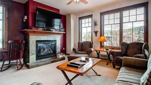 A living room with a fireplace, a television, and comfortable seating.