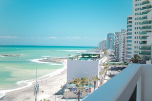 Un paysage urbain côtier avec une plage, des immeubles de grande hauteur et un ciel dégagé.
