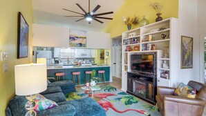 A living room with a sofa, a coffee table, a fireplace, and a bookshelf. - Walk to Beach! Romantic 'Deja View' Apt in Biloxi (Biloxi)