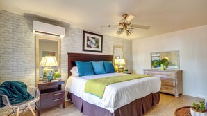 A bedroom with a bed, nightstands, a dresser, a chair, a mirror, and a ceiling fan. - Walk to Beach! Romantic 'Deja View' Apt in Biloxi (Biloxi)