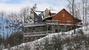 A wooden cabin with a stone chimney, a balcony, and a view of the surrounding trees. - AWESOME View 2500 sqft decks 8 person Spa mins to Blue Ridge Pkway & New River (Fleetwood)