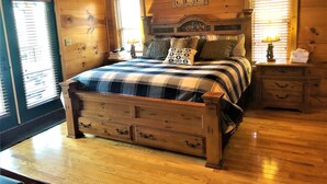 A wooden cabin bedroom with a bed, nightstands, and a dresser. - AWESOME View 2500 sqft decks 8 person Spa mins to Blue Ridge Pkway & New River (Fleetwood)
