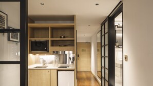A modern kitchen with wooden cabinets, a stainless steel sink, and a built-in refrigerator. - KéSa House by The Unlimited Collection managed by The Ascott Limited (Singapore)
