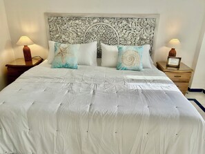 A neatly made bed with a white bedspread and decorative pillows, flanked by two bedside tables with lamps. - Colonial townhouse in the Old City with panoramic ocean views (Cartagena)