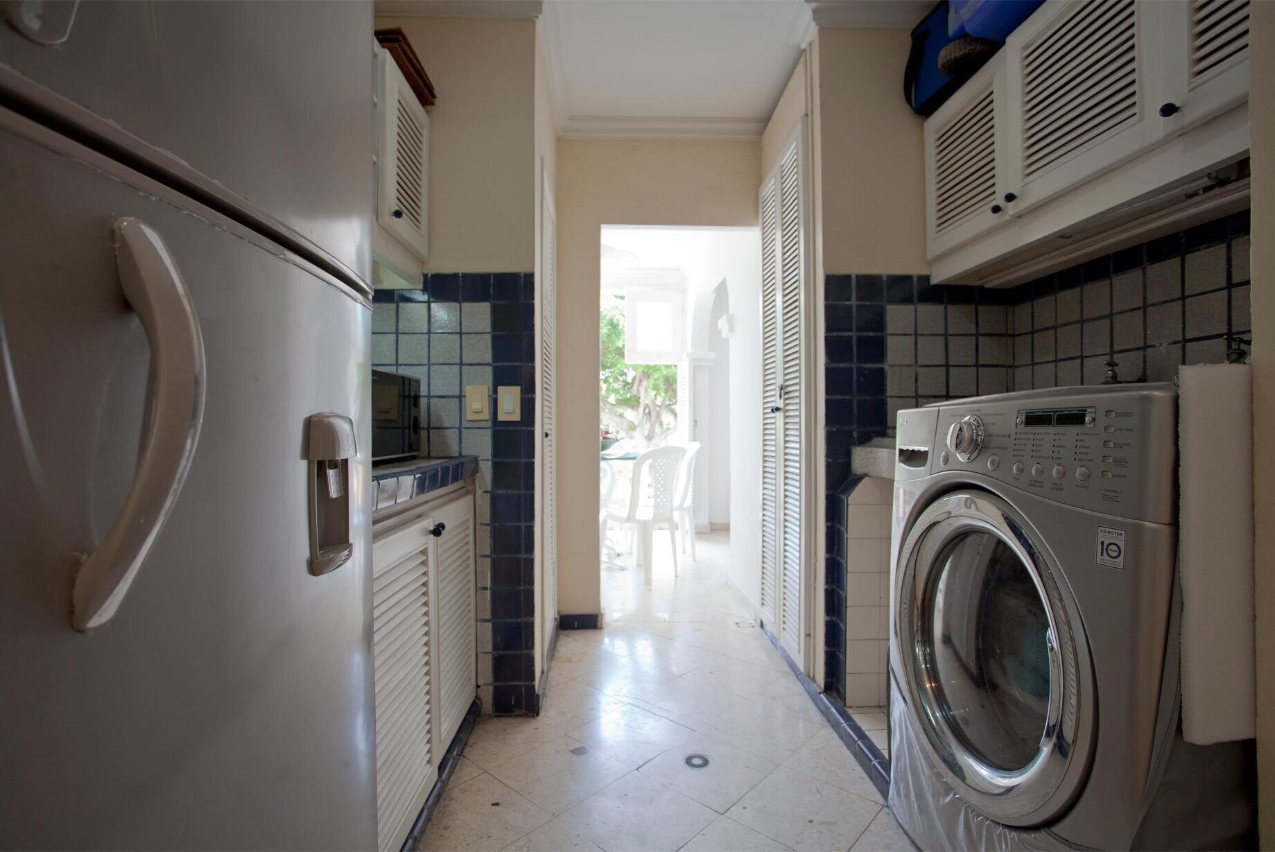 Een wasserette met een wasmachine, een droger en een koelkast.