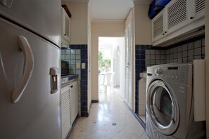 A laundry room with a washing machine, a dryer, and a refrigerator.