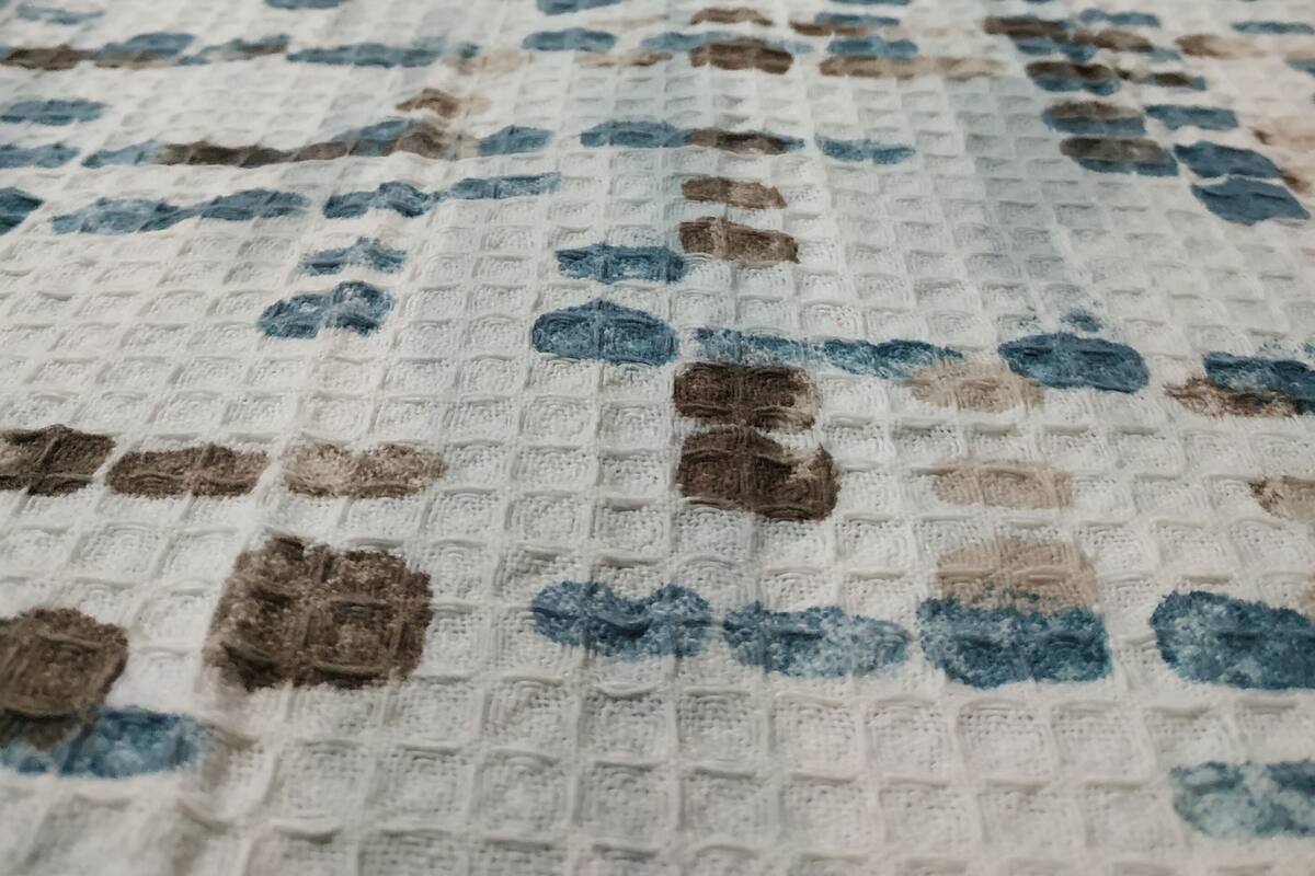 A bed with a patterned bedspread and pillows.