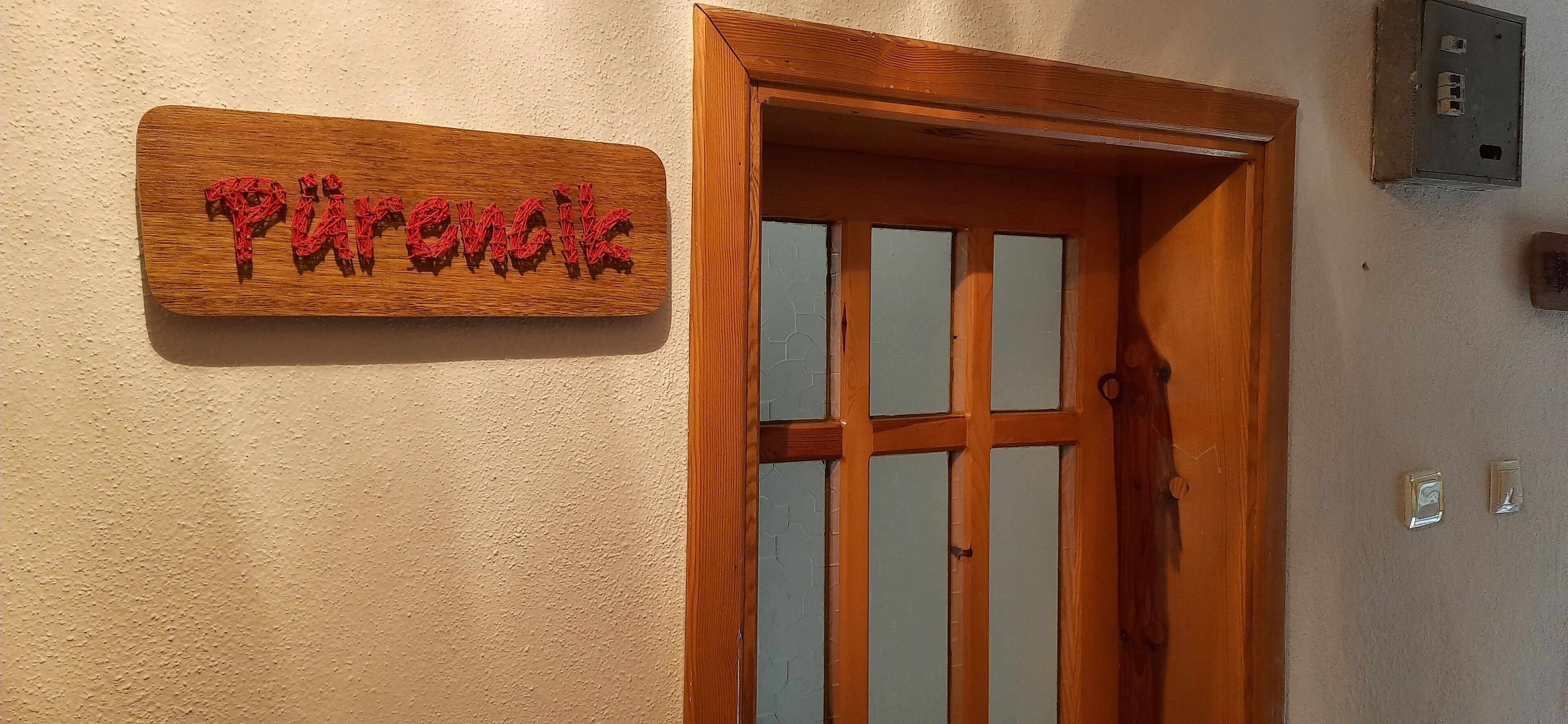 A wooden door with a frosted glass panel and a wooden sign above it reading "Pharmacy".