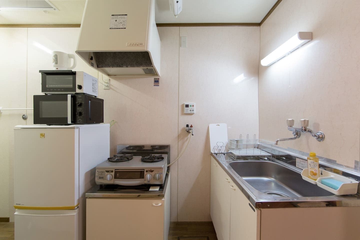 A compact kitchen with a microwave, stove, and sink.