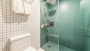 A bathroom with a shower, toilet, and tiled walls. - Hannam 67 (Seoul)