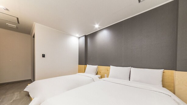 A hotel room with two beds, a wooden headboard, and a neutral color scheme. - Hannam 67 (Seoul)