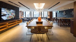 A modern conference room with a long table, chairs, a large screen, and a chandelier. - Sotetsu Fresa Inn Seoul Myeong Dong (Seoul)