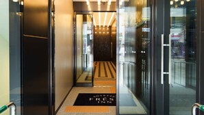 A hotel entrance with a modern design, featuring a glass door, a black reception desk, and a sign above the door. - Sotetsu Fresa Inn Seoul Myeong Dong (Seoul)