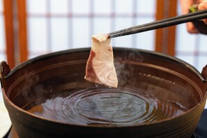 Une grande marmite munie d’une anse, probablement utilisée pour la cuisson ou pour faire bouillir de l’eau.
