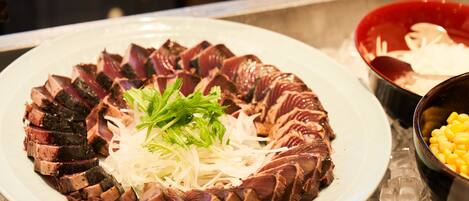 A plate of sliced meat with shredded vegetables and a garnish.