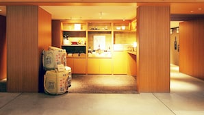 A hotel lobby with a reception desk, wooden paneling, and a carpeted floor.
