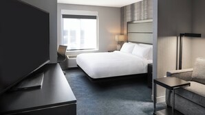 Een moderne hotelkamer met een groot bed, een flatscreen televisie, een bureau en een bank.
