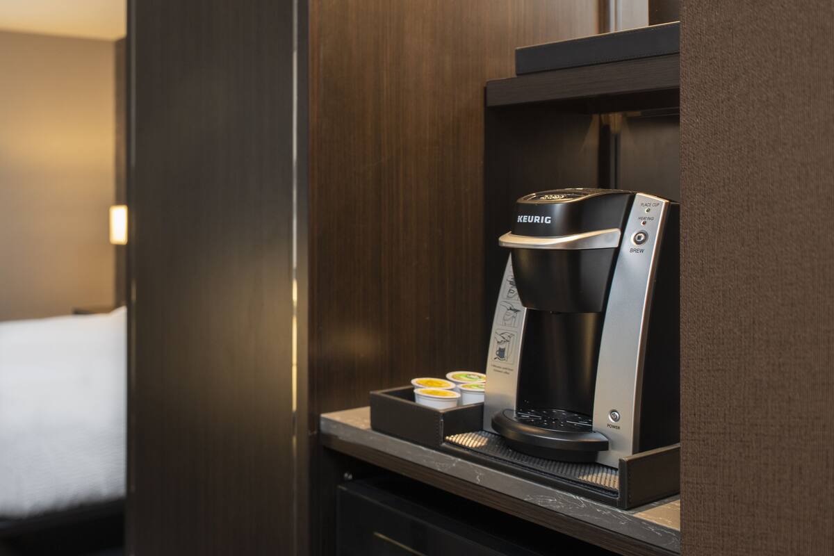 A Keurig coffee machine with a drip coffee maker, a coffee pod holder, and a power button.