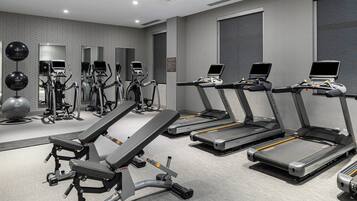 A gym with treadmills, elliptical machines, and free weights.