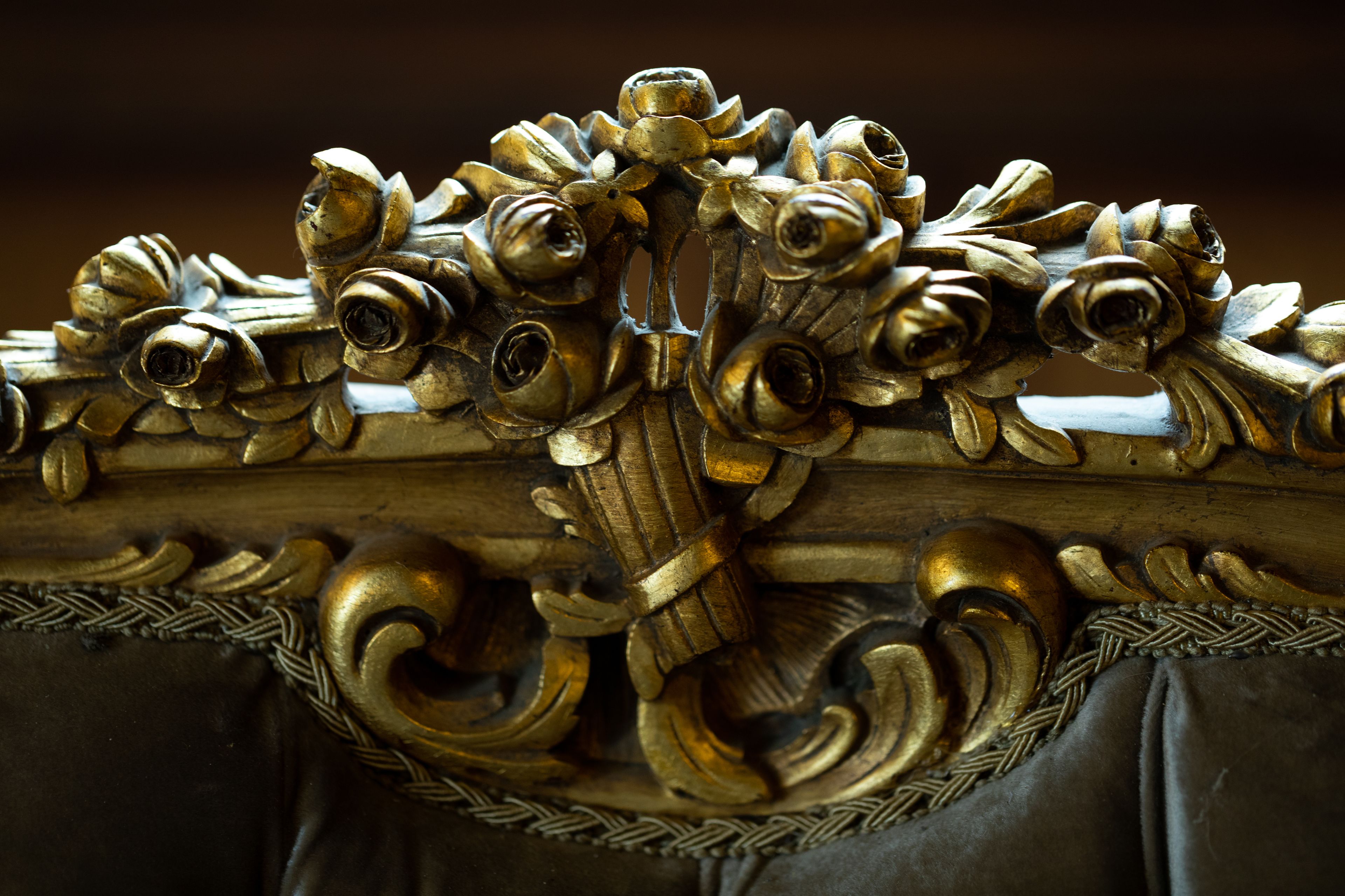 Un detallado diseño ornamental dorado con motivos florales y en volutas.