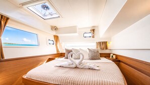 Una cabaña lujosa con una cama grande, tragaluces y vista al mar.