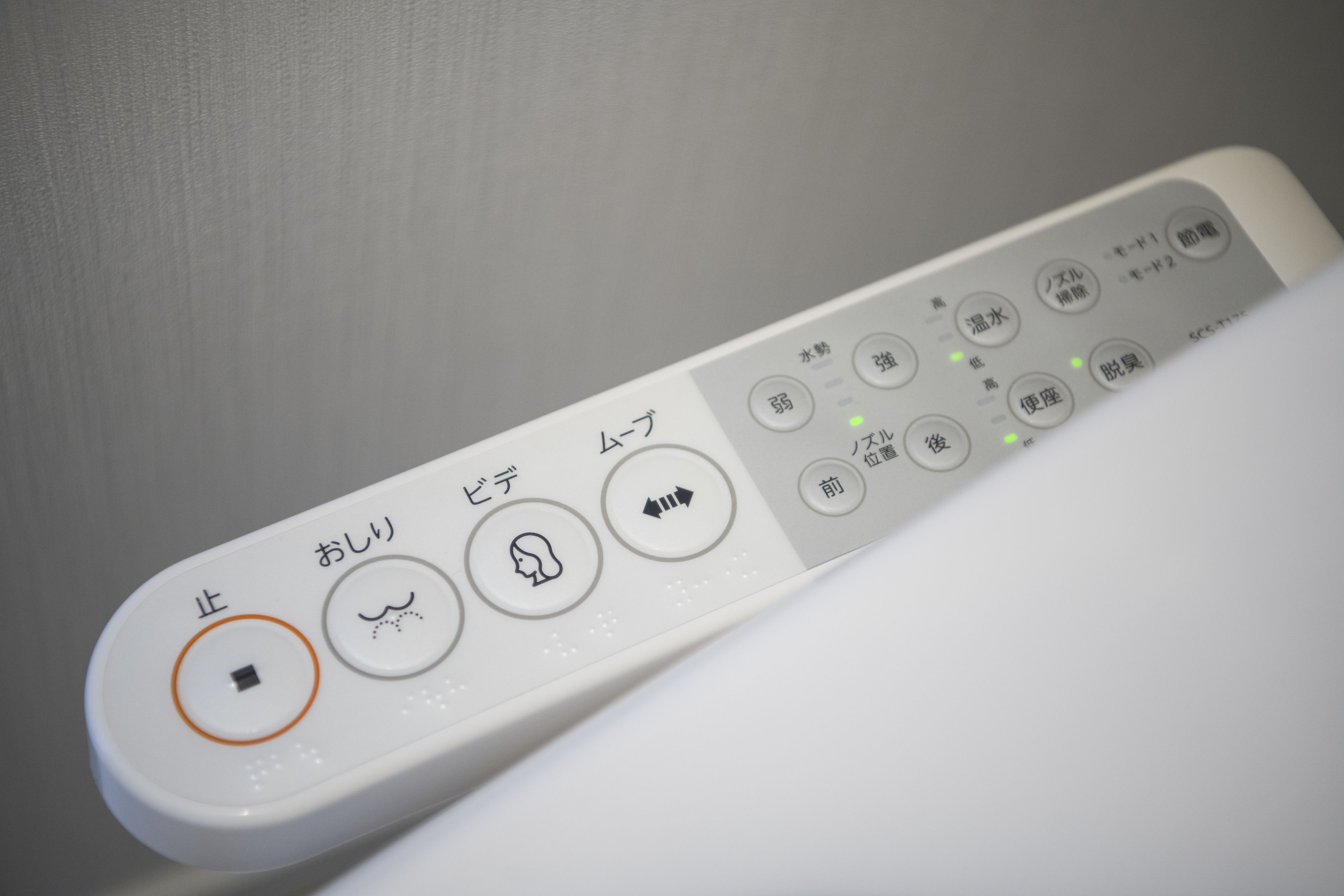A white remote control with Japanese text and symbols.