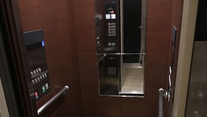Een lift met een bedieningspaneel, een spiegel en een vloerkleed met het logo 'URBAN SEA'.