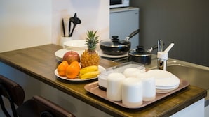 Een aanrecht met fruit, een magnetron en een spoelbak.