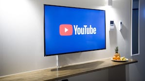 Een flatscreen-tv aan een muur, waarop het YouTube-logo te zien is.