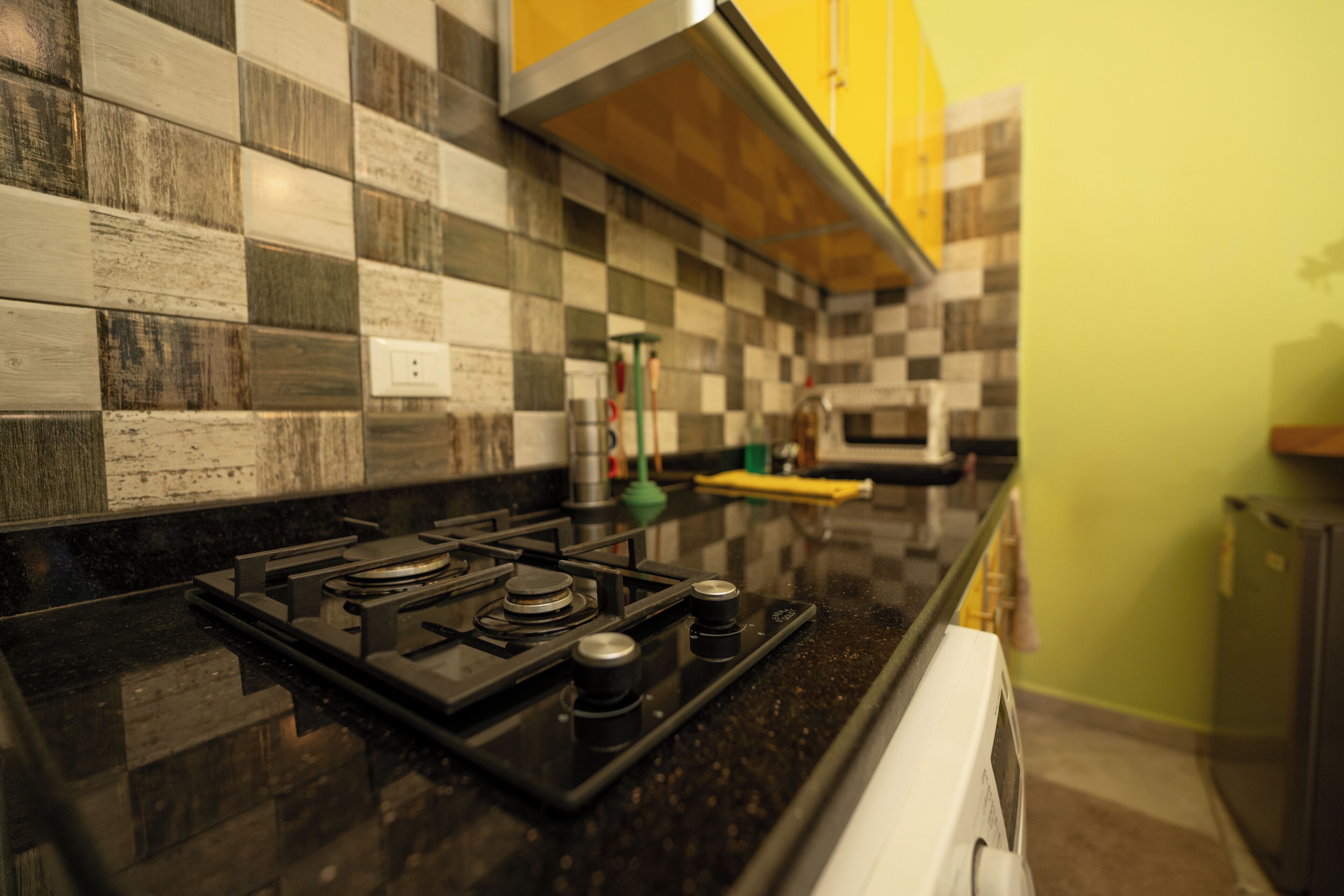 A kitchen with a black countertop, a gas stove, and a microwave.