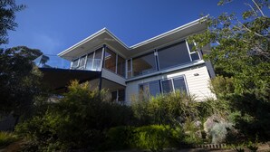 A modern two-story house with large windows, surrounded by dense greenery. - Beach Side Bay Of Fires (Binalong Bay)