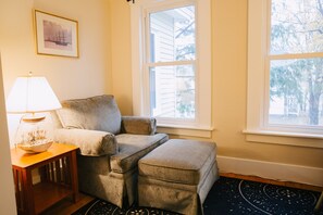 A cozy living room with a sofa, a side table with a lamp, and a rug. - Harbor House: Sleeps 20, Fireplace, 2 TVs, 2 kitchens, walk to restaurants/bars (Sunapee)