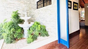 A modern interior with a stone wall, a blue door, and a welcome mat.