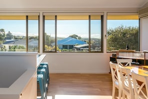 A modern kitchen with large windows, a dining area, and a logo indicating pet-friendly accommodation.