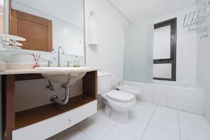 A modern bathroom with a sink, toilet, and bathtub.