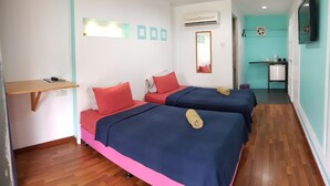Una habitación con dos camas, un escritorio pequeño, un espejo y una kitchenette.