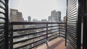 A balcony with a metal railing overlooking a cityscape. - Dean Funes X22 (Córdoba)