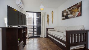 A room with a bed, a TV, a wooden cabinet, and a painting on the wall. - Dean Funes X22 (Córdoba)