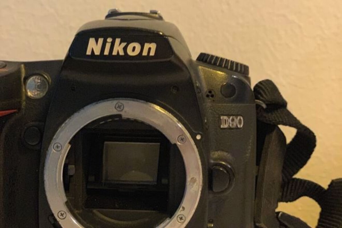 A Nikon camera with a viewfinder and a strap.