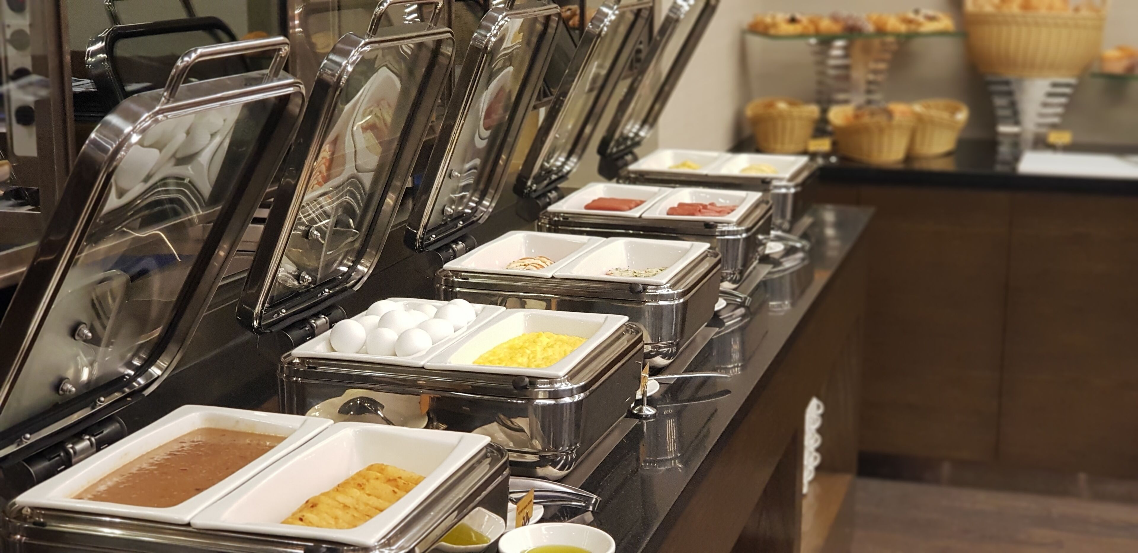 Un bufé con diferentes alimentos en recipientes separados.