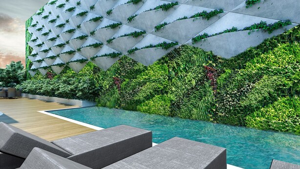 Un área de piscina moderna con un diseño de pared geométrico y abundante vegetación.