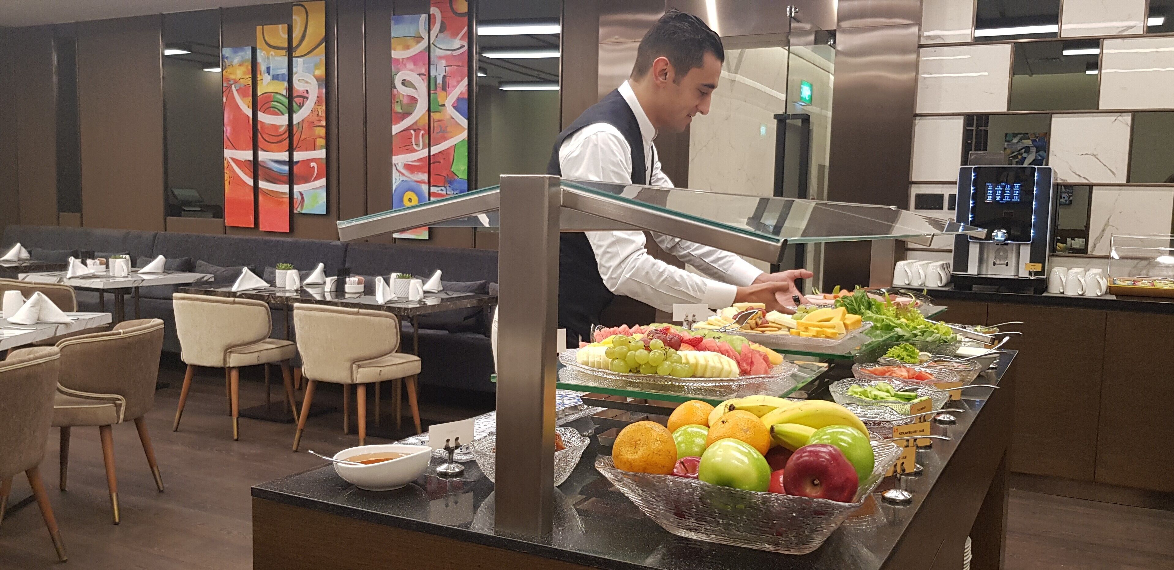 A buffet area with various fruits and a water dispenser.