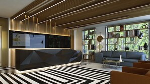Un vestíbulo moderno con un mostrador de recepción de diseño geométrico, un sofá y una estantería llena de libros.